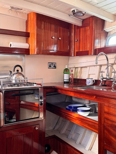 Galley with mahogany cabinetry and stainless steel appliances